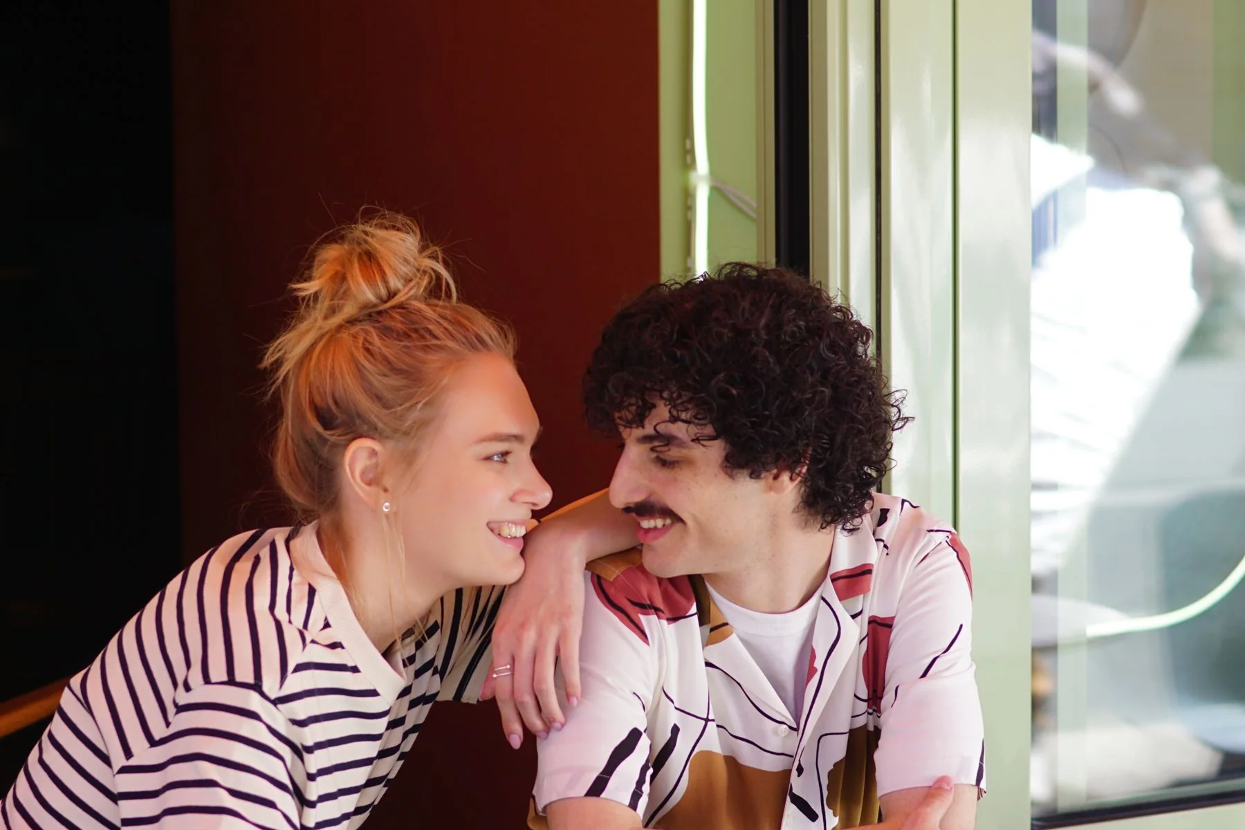 Two adults smiling together during a relaxed café date